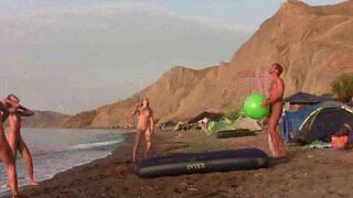 A young girl is playing badminton naked on the nude beach