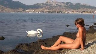 A hot naked girl is walking on the riverbank