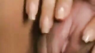 A girl with a big clitoris plays with her hairy cunt