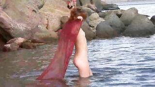 A sexy girl with small boobs gets them wet in the river