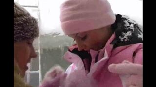 Two lesbians having fun in the snow on a cold winter day