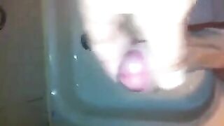 The kid caresses his dick in the shower, imitating sex with a girl