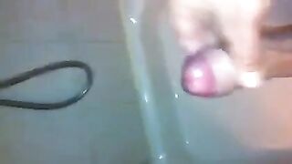 The kid caresses his dick in the shower, imitating sex with a girl