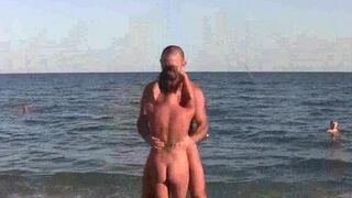 A group of acrobats perform without clothes on the sandy coast