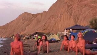 A group of naked beauties play volleyball on the nude beach