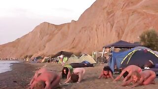 A group of naked beauties play volleyball on the nude beach